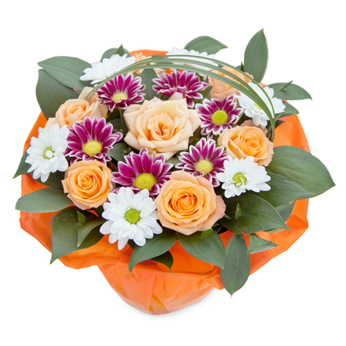 This bouquet, artfully captured from a top-down angle against a clean white background, encapsulates the richness and vitality of Golders Green's vibrant spirit. At its core, lush roses unfurl their petals in a gentle ombré of soft peach and vivacious orange, exuding warmth akin to a glowing sunset over Golders Hill Park. Surrounding these central roses, charming chrysanthemums offer balance: those with delicate white petals and green centers echo the classic appeal of wild daisies in local meadows, while the striking magenta-purple blooms introduce electric color notes, their lime-green discs promising an eye-catching twist. The ensemble is nestled within deep, glossy green leaves-possibly ruscus or salal-that bring a woodland freshness and a sense of fullness, reminiscent of the thriving greenery lining North End Road. A graceful swoop of bright green decorative grass adds a contemporary touch, arcing elegantly above the bouquet like a stroke of artistry. Completing this composition, the entire base is neatly wrapped in crinkled orange cellophane, bringing together the lively hues of the roses and making the bouquet feel as celebratory as a local festival. Meticulously designed, this arrangement channels the nurturing expertise of Golders Green florists-its joy and beauty ideal for gifting, home decor, or honouring special events within the NW11 community.