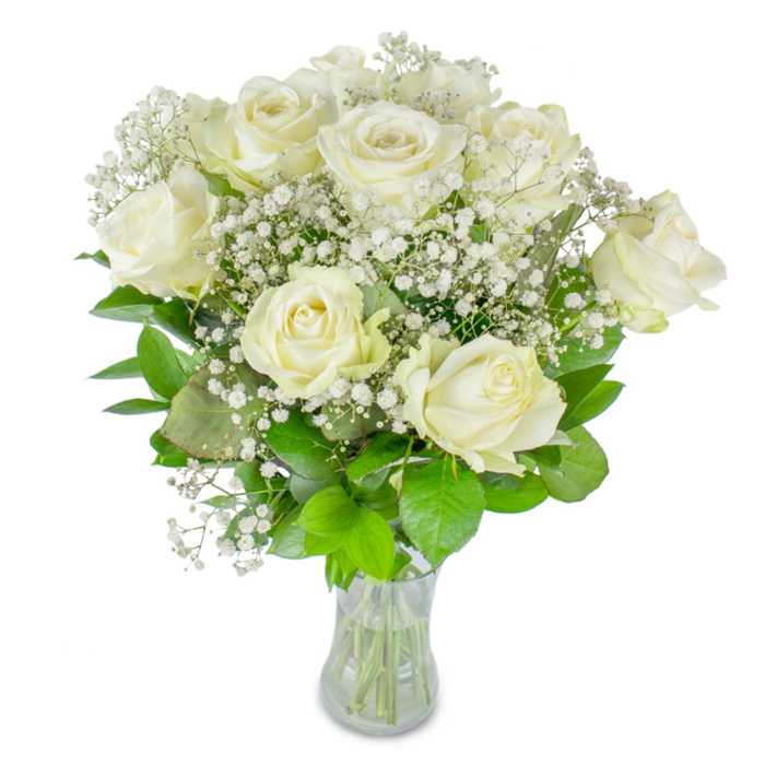 A refined arrangement of about a dozen pristine white roses intertwined with delicate baby's breath (Gypsophila) rests in a clear glass vase against a minimalist white backdrop, described here with the familiarity of a local Golders Green floral artist. The roses vary in stage - some fully expanded with creamy, satin-like petals curling outward, others tenderly opening - giving the bouquet a lived-in, breathing quality. Tiny, starlike clusters of baby's breath float around and between the main blooms, creating a soft, lacey veil that lightens the composition and lends a romantic, almost vintage air. Underneath, a mix of deep emerald and lighter lime leaves provide a fresh, structural base; their cool sheen and veination add depth and a verdant contrast that lets the whites read as luminous rather than stark. The clear glass vase displays neat, water-submerged stems and a visible water line, a simple detail that conveys freshness and attentive preparation. Gentle, diffused lighting accentuates the subtle shadows and highlights on the petals, enhancing their silky texture.

This bouquet carries an emotional palette of calm celebration and respectful remembrance - fitting for weddings, milestone anniversaries, or moments of quiet reflection. The fragrance is unobtrusive, a faint green sweetness that suggests early spring sunlight and the calm of nearby Finchley Road mornings or a stroll through Hampstead Garden Suburb. From a florist's viewpoint, assembling these elements is an exercise in restraint: allowing the purity of white and the fine architecture of gypsophila to speak, while the foliage anchors the arrangement with reassuring clarity.