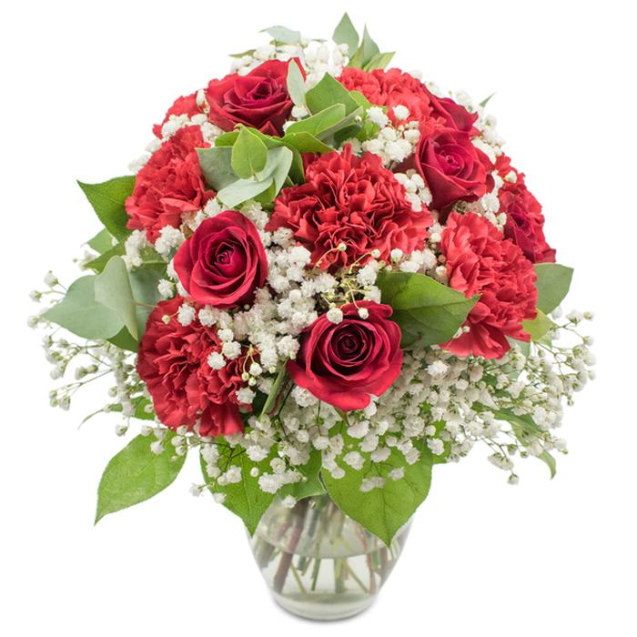 This image shows a beautifully composed red and white floral bouquet arranged with classic elegance in a simple clear glass vase, set against a pure white studio background that makes the colours appear especially vivid. Deep red roses anchor the design, their velvety petals tightly coiled into graceful spirals, each bloom suggesting devotion and quiet passion. Around and between them, generous tufts of red carnations expand the bouquet, their finely ruffled petals building layers of texture and creating a lush, rounded, almost domed profile that feels both abundant and carefully controlled. Interlaced with these rich red flowers are airy clouds of white baby's breath (Gypsophila), their minute, star-like blossoms filling small gaps and giving the whole arrangement a soft halo of brightness, as if wrapped in a gentle mist. Accents of fresh greenery, including deep green rose foliage and muted, silvery-green eucalyptus leaves, add structural interest and a cool, natural counterpoint to the warmth of the reds, much like the tranquil greenery that softens busy corners around Golders Green Road. The clear glass vase reveals the straight, neatly trimmed stems gathered together, immersed in clean water that catches the light, underscoring the freshness and skilled conditioning behind the display. Even, bright lighting eliminates harsh shadows and brings out the true tones of the flowers, highlighting every curve and edge of the petals. The bouquet radiates a sense of romance, warmth, and tradition, perfectly suited to an intimate dinner at home in Golders Green, a special anniversary surprise, or a thoughtful same-day delivery to convey love, gratitude, or heartfelt congratulations within the local community.