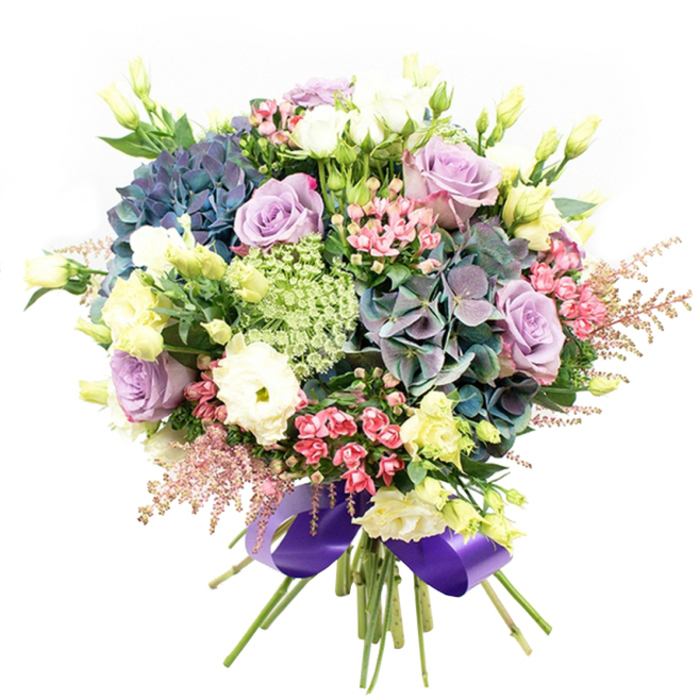 A striking vision of floristry unfolds in this abundant bouquet, crafted with care by the artisans at Flowers Golders Green for delivery throughout the local area. Majestic clusters of blue, teal, and muted purple hydrangeas act as the visual anchor, their plush petals offering both depth and volume, much like a woodland glade tucked behind Golders Green's leafy avenues. Delicately unfurled lavender and creamy white roses intermingle with full, cup-shaped ranunculus-each blossom meticulously placed to capture both romance and freshness. Muted yellow-tinged eustoma stems punctuate the composition, their slender forms lending height and an airy texture, reminiscent of the early blooms that appear each spring along the paths of Golders Hill Park. At the edges, lively sprays of fuchsia-pink blossoms and blush astilbe plumes provide whimsical movement and luminous accents, softly blending into the arrangement along with intricate lace-like green filler flowers that add subtle botanical detail. Polished green foliage is weaved thoughtfully to frame the bouquet, enhancing the natural palette and offering a serene contrast to the more vibrant blooms. The stems are neatly gathered and encircled with a wide, lustrous royal purple ribbon, its deep sheen echoing the bouquet's cool colour story and suggesting a final note of luxury. Whether adorning a dinner table off Finchley Road or marking a treasured milestone, this bouquet embodies both refined artistry and genuine warmth-classic touches of Golders Green charm in every petal.