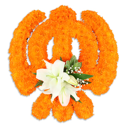 Set against a clean white backdrop, this floral rendition of the Khanda is composed with careful, traditional craftsmanship: thousands of small, bright orange marigold blossoms are densely arranged to form the central chakkar, the pair of crossed kirpans and the downward-pointing dagger, their clustered petals giving the symbol a lively, tactile surface that glows in diffused light. Nestled precisely at the intersection of the swords is a refined cluster of white lilies-at least two fully opened blooms with their soft, curving petals and subtle green-yellow stamens-encircled by a handful of smaller buds and delicate sprays of baby's breath. Lush green leaves, selected for contrast and structure, fan out discreetly behind the lilies, offering depth and a cooling visual rest from the intense orange. The slight shadow beneath the arrangement suggests it sits as a self-supporting tribute or altar piece, crafted to be viewed from the front in a Gurdwara or at a commemorative event. This piece reads as both festive and solemn: the marigolds' celebratory hue evokes Vaisakhi processions and community gatherings across neighbourhoods like Golders Green Road and Temple Fortune, while the white lilies and gypsophila lend a tone of reverent grace for anniversaries and memorial observances. Locally prepared by experienced hands at Flowers Golders Green, the composition balances bright colour, delicate fragrance, and cultural respect-an offering that speaks of continuity, care, and the quiet dignity of ritual.