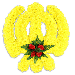 This floral Khanda is an intimate lesson in colour and craft - the Sikh insignia rendered in a sea of densely arranged yellow chrysanthemum blooms, their small, ruffled faces packed so closely they form a plush, sculptural surface that describes the chakram's circle, the central double-edged khanda and the two crossed kirpans with precise, confident lines. At the emblem's heart a compact cluster of five to six deep red roses sits atop a bed of dark green fern fronds, the lush foliage cradling the roses so their velvety petals read as a deliberate, respectful focal point against the expansive yellow. Photographed on a crisp white backdrop with a soft shadow beneath, the piece reads as a standalone tribute - suitable for a religious service or a dignified memorial - and the balance of colour and texture carries a quiet, consoling dignity. As a local florist with roots in the area, I picture this arrangement delivered with care across Golders Green and nearby Finchley Road, arriving at services near Golders Green Crematorium or placed at family gatherings in Hampstead Garden Suburb. The floral perfume would be restrained: the green freshness of ferns, the mild, honeyed scent of chrysanthemums and the warm, familiar aroma of roses. Prepared with cultural sensitivity and technical skill, this Khanda wreath speaks to remembrance, faith and communal respect; it's the kind of piece we might create at Flowers Golders Green for community ceremonies and private remembrances alike.
