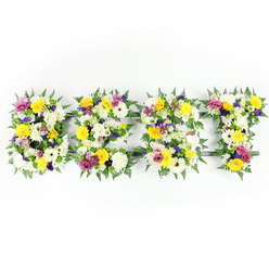 Presented flat against a clean white background and lit with steady daylight-equivalent lighting, this bespoke floral tribute spells "BEST" in four bold, letter-shaped panels, each lovingly constructed from dense clusters of fresh blooms and rich foliage. The dominant palette is crisp white and cheerful yellow: plush white chrysanthemum-like blooms and ivory gerberas create a serene base while bright yellow roses and gerbera daisies bring a sunlit warmth. Interspersed are gentle lavender and deeper purple lisianthus or similar small chrysanthemums that lend quiet dignity, and vivid fuchsia-pink spray roses or carnations provide lively accents. Tiny green and white filler blossoms give tactile interest and help the letters hold a soft, sculpted surface, while generous fern fronds cradle each form with deep, glossy green, creating a natural border. A discreet dark-green or grey metal armature shows through in places - particularly across the middle bar of the 'E' and the top of the 'T' - revealing the experienced construction beneath the floral sweep. The overall effect is calm but uplifting, a carefully balanced piece that speaks of honour and fond remembrance. As Flowers Golders Green would arrange for families in the area, this composition is suitable for funeral services at nearby Golders Green Crematorium or for a memorial tribute laid at a local synagogue, conveying love and respect through handcrafted floristry. The scent is quietly floral and comforting, and the design is sized for easy transport and local delivery around Golders Green and Finchley Road.