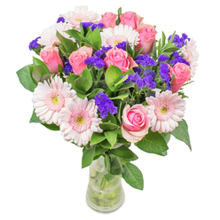 Every bouquet I arrange in Golders Green draws inspiration from the lively yet peaceful character of our neighbourhood, and this particular arrangement radiates that local spirit. As I place each stem, I'm struck by the tender interplay between pastel gerberas, their blush-pink petals reminiscent of spring mornings on Hoop Lane, and the soft, classic roses in varying shades of pink. The colours overlap gently, blending like gentle watercolours in rain-washed shop windows along the high street. Deep purple statice, with its crisp, textured blooms, adds a fresh accent-like wildflowers glimpsed in Golders Hill Park, playful yet refined. Dewy, cool green foliage grounds the composition, bringing a touch of nature indoors and adding that vital freshness only a florist who truly cherishes their blooms would select. Captured in an understated glass vase, the bouquet feels airy, luminous, and inviting. The light seems to bounce from petal to petal, creating an almost glowing effect. Crafted for both special occasions and everyday moments-a thoughtful 'get well soon' for a recovering friend, a cheerful centrepiece for a North London living room-this bouquet embodies careful craftsmanship, local pride, and a sense of joy unique to Golders Green.