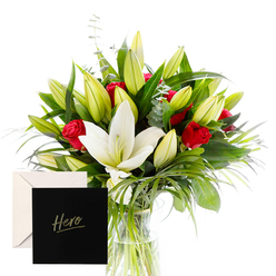 Flowers Golders Green offers a portrait of sophistication and emotion, carefully composed to evoke both admiration and comfort. The white lilies, large and trumpet-shaped with creamy petals, open like gentle beacons among abundant green spears and curls of foliage. Red roses cluster passionately throughout the arrangement, their fragrance mingling with the lilies in a dewy, hypnotic aroma. The abundance of unopened buds promises beauty yet to come, offering a sense of hope and ongoing celebration. The natural arrangement is caught in bright, clear light, each leaf and petal outlined in freshness. Presented with an elegant card marked 'Hero,' this creation is an ideal expression of thanks or remembrance-a floral embrace for someone whose spirit inspires. Crafted by Flowers Golders Green for delivery to Golders Green and the surrounding NW11 locales such as Cricklewood, Hampstead Garden Suburb, and Finchley Road, it brings a sense of grace to any occasion. Available for same-day delivery across Golders Green, Hendon, and nearby areas, so the sentiment arrives promptly. The bouquet feels timeless yet modern, a quiet reminder of courage and kindness, and its fragrance lingers in the room like a warm memory. It is a thoughtful tribute for anniversaries, memorials, or moments when you want to mark someone who inspires others.