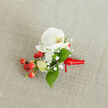 A meticulously crafted floral boutonniere is laid neatly on a softly textured, light beige woven fabric, similar to natural linen, creating a calm, neutral backdrop that lets every detail stand out. At the heart of the design is a single pristine white Phalaenopsis orchid, its broad, velvety petals gently unfurling like butterfly wings, with a warm creamy yellow and soft orange throat adding a glowing depth at the centre. Surrounding the orchid are tiny clusters of cloud-like white baby's breath, their airy blossoms forming a delicate halo that softens the composition and lends a romantic, almost weightless feel. Tucked to one side, a bright cluster of glossy, round red berries introduces a joyful, festive pop of colour, balanced by a few paler green, oval buds that hint at freshness and new growth. Lush green leaves in varying shapes - some broader and pointed, others slimmer and more elongated - weave through the flowers and berries, offering a natural frame and a cool contrast to the white and red elements. The stems are carefully bound at the base with a deep red satin ribbon, folded and wrapped with the precision of an experienced florist from Golders Green, then finished in a neat knot with short, tidy tails that rest against the fabric. The lighting is soft and even, suggesting gentle daylight filtering through a North West London window, and the overall mood is refined yet warm. This small but striking floral accessory feels perfect for a winter wedding boutonniere, a prom, or a formal celebration around Golders Green, capturing the quiet excitement of a special day in a single, wearable piece of floral art.