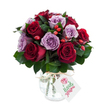 A lush, hand-crafted bouquet of fully opened roses that reads like a small poem in colour: velvety deep crimson and burgundy blooms clustered with soft lavender and lilac roses, their petals unfurling in layered spirals. The round, abundant composition sits compactly so each rose face is visible; the darker red tones anchor the arrangement while the pale purples lift it with a gentle, romantic air. Interleaved among the roses are glossy, dark green leaves - likely Ruscus or Salal - that give the bouquet depth and a cool, leafy backdrop, and small, bright red-orange rose hips tucked into the spray add a rustic flicker of warmth and texture. The stems are arranged within a reflective mercury-glass vase, its silvered, mottled surface catching light and softening the palette with antique shimmer; a natural raffia tie at the neck lends a handcrafted, country touch. A simple white rectangular gift tag with a tiny rose illustration hangs from the ribbon, angled forward but without any visible brand name, making the arrangement feel personal and ready to present. Photographed against a clean white background, the colours pop with clarity and freshness - you can almost sense the faint, green-tinged scent of roses and the cool weight of the glass. This bouquet carries a quiet, luxurious feeling suited to anniversaries, thoughtful apologies, or a heartfelt gift brought home from a stroll through Golders Hill Park to someone you love, reflecting the careful eye of a local florist who knows how to balance colour, texture and sentiment.