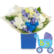 A joyful, welcoming composition of fresh flowers arranged as a gift for a newborn boy: a lush, round bouquet set into a sturdy royal-blue presentation box, the deep matte finish anchoring a soft, celebratory palette of whites, blues and pale purples. At the heart, creamy white roses and elegant white lilies-some just unfurling-offer a quiet, creamy fragrance and silky petal texture, supported by full, fluffy white chrysanthemums that add volume and a cloud-like softness. Electric blue chrysanthemums and a concentrated cluster of vivid cobalt blooms draw the eye as a bold focal point, while smaller lavender or periwinkle sprays-reminiscent of hyacinth or campanula-weave delicate, bell-shaped texture through the arrangement. Fresh green foliage, including broad glossy leaves and feathery fern fronds, frames the flowers and gives depth and contrast against the cream tissue wrapping gathered around the base. To the right, a light-blue foil balloon in the shape of an old-fashioned baby carriage floats slightly, its canopy and wheels picked out in darker blue with polka-dot and heart details; the phrase It's a Boy appears in cheerful yellow and lime-green lettering across the carriage. Soft daylight highlights the satin sheen of petals and the subtle scent of lilies, making the set feel perfect for a hospital visit, a baby shower, or a front-door welcome. As a local florist in Golders Green I often prepare this combination for new parents around Golders Hill Park and nearby Finchley Road, available for careful same-day delivery across the neighbourhood.