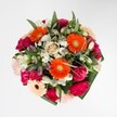 A joyful celebration of vibrancy and texture, this bouquet channels the welcoming spirit of Golders Green with every petal and leaf. At its centre, exuberant orange gerberas command attention, flooding the arrangement with cheerful energy under the soft light that filters through northwest London's leafy lanes. Plush magenta carnations and delicate blush-pink roses add sumptuous softness, each bloom rich and full, inviting you to linger over their velvety forms. Whisper-light white alstroemeria and tiny daisy clusters sparkle throughout, recalling early morning dew on lawns near Central Square. The foliage is generous but never overwhelming, with glossy, emerald-green leaves enveloping the bouquet and adding depth and structure, reminiscent of a freshly gathered posy from local Golders Green gardens. The palette is deliberately harmonious: the warmth of the pinks and oranges balanced by cool whites and lush greens, all coming together in a composition that radiates both optimism and artistry. This bouquet is perfect for marking special days-a milestone birthday, a heartfelt thank you, or simply the desire to fill a home near Brent Cross with colour and gentle fragrance. Crafted with a sense of care and joy unique to Golders Green, this arrangement promises a touch of local summer all year round.