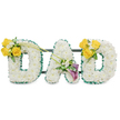 A three-dimensional memorial display spells out the word DAD in large, freestanding capital letters, each letter built from a dense carpet of pristine white spray chrysanthemums that give the shapes a soft, pillowed texture. The outer and inner contours of every letter are neatly edged with a ruffled, deep green satin ribbon that cuts a crisp line against the white blooms and reads like a protective frame. Thin, dark-green metal support bars run horizontally behind the letters, visible in gentle shadow and lending a structural, gallery-like calm to the composition. The whole piece is photographed against a plain white background so the purity of the whites and the fresh sheen of the green border remain the focus.  Each letter bears its own floral accent. The left D is warmed by a cluster of three to four bright yellow roses set on the upper left curve, accompanied by tiny white filler blooms-freesias or gypsophila-and fresh green foliage; two long, bare green stems arch upward from that cluster toward the centre. The central A is anchored low on its left leg by a refined spray featuring two deep purple to burgundy calla lilies, their trumpet forms offering a dignified focal point surrounded by small white accents and glossy leaves. The right D mirrors the left with another cheerful yellow-rose cluster on its upper right curve, balancing the tribute. There is a subtle, clean fragrance of freesia and rose, a quiet brightness that complements the sober purpose. As a funeral or memorial piece the arrangement reads as thoughtful and bespoke: white for peace, yellow for cherished memories, and purple for reverence, designed to give comfort during a goodbye and to honour a beloved father in a calm, considered way.