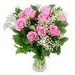 A charming bouquet of soft pink roses and airy white baby's breath is presented in a clear glass vase, standing alone against a pure white background that emphasizes its gentle colours and finely crafted shape. Around a dozen roses form the core of the design, their petals unfurling in layered spirals that move from a light, almost blush pink at the outer edges to a slightly richer pink in a few of the central whorls, lending a subtle depth to the arrangement. Some blooms are fully open and expansive, while others remain slightly cupped and youthful, creating a natural rhythm that feels both fresh and serene. Between the roses, sprigs of baby's breath weave in and out, their tiny white blossoms clustered like little stars, softening the lines of the bouquet and giving it a cloud-soft, almost whisper-light texture. Dark green foliage frames the flowers, with leaves that look freshly cut and gently glossy, providing a deep contrast that makes the pastel tones glow more vividly. The stems are neatly gathered and visible through the transparent vase, resting in clear water, which conveys the care and professionalism one would expect from Flowers Golders Green preparing a new baby gift for a local family. The lighting is bright yet diffused, without harsh shadows, so that every petal and leaf appears crisp, clean, and full of life. This tender, romantic arrangement is perfectly suited to celebrate a new baby in Golders Green, to decorate a peaceful nursery near Brent Cross, or to accompany an article on baby flowers, gentle pastel arrangements, and thoughtful, locally delivered gifts for growing families.