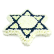 A meticulously composed Star of David floral tribute fills the frame, its strong lines and quiet symbolism made entirely from compact, many-petalled blossoms. Against a pure white background, the six-pointed star appears almost to float, every edge precisely defined by a generous border of crisp white chrysanthemums. Within this outline, a broad central hexagon and the six slim triangles that point inward from each star tip are also carpeted with white flowers, building a soft, glowing core. In striking contrast, the two overlapping triangles that create the classic Magen David silhouette are densely packed with deep navy blue blooms, arranged so carefully that the colour seems solid and unwavering. The floral surface is thick and cushioned, suggesting the gentle give you would feel if you touched it, and each flower head is turned outward, showing off its full, rounded shape. The overall palette of white and blue clearly recalls the colours of the Israeli flag, underscoring the tribute's connection to Jewish heritage and faith. This is the kind of arrangement often chosen by families in Golders Green, close to Brent Cross and Temple Fortune, when marking a funeral, unveiling or memorial service, where the emphasis is on dignity, tradition and heartfelt remembrance. The lighting is soft and even, with no harsh shadows, helping the star's geometry stand out cleanly and giving the piece a calm, contemplative presence. Everything about the design-from the symmetry of its points to the balanced distribution of colour-conveys care, respect and a deep understanding of Jewish mourning customs.